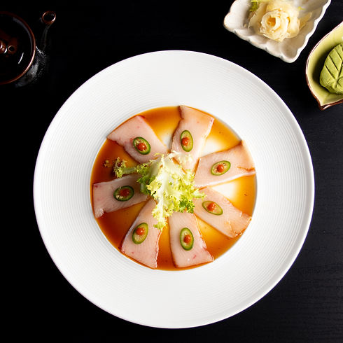 Delicious sashimi dish on a white plate with decorative garnishes. Sakana.